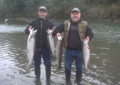 Two fisherman holding 4 nice fish in Oregon.